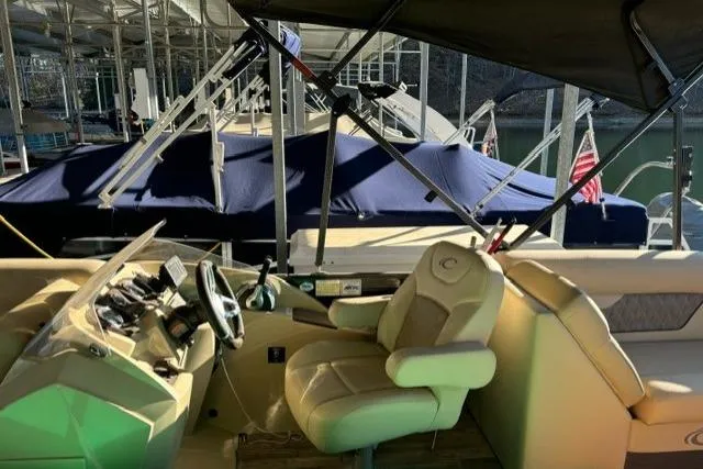 Slide: The Image of 2019 Crest 220 CREST II boat interior with steering wheel and seating at marina. - 5