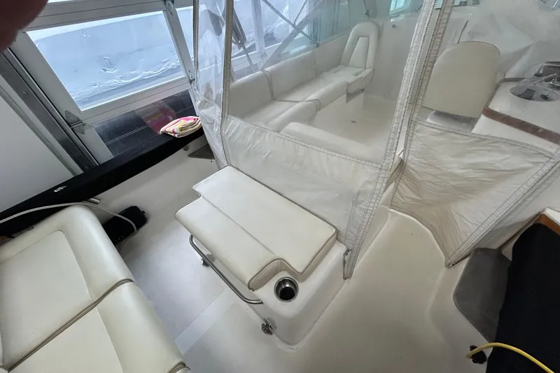 Slide: The Image of 2007 Hunt Yachts Harrier 25 interior with white seating and clear enclosure. - 19