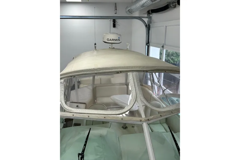 Slide: The Image of 2007 Hunt Yachts Harrier 25 in garage, featuring Garmin equipment and protective cover. - 6