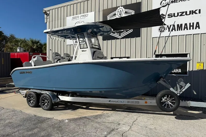 The Image of 2026 Sea Pro 245FLX Sandbar boat on trailer, parked outside dealership. - 1