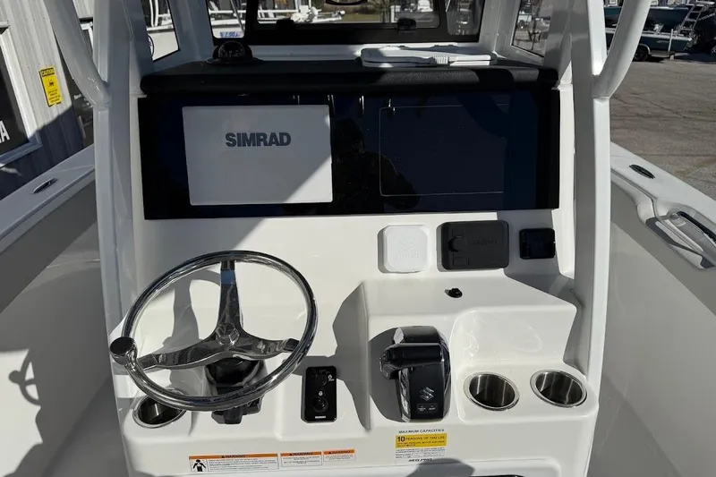 Slide: The Image of 2026 Sea Pro 245FLX Sandbar boat console with Simrad display and steering wheel. - 16
