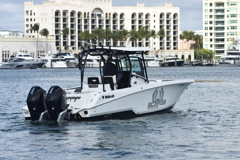 The Image of 2021 Wellcraft 302 Scarab boat cruising near luxury waterfront buildings. - 0