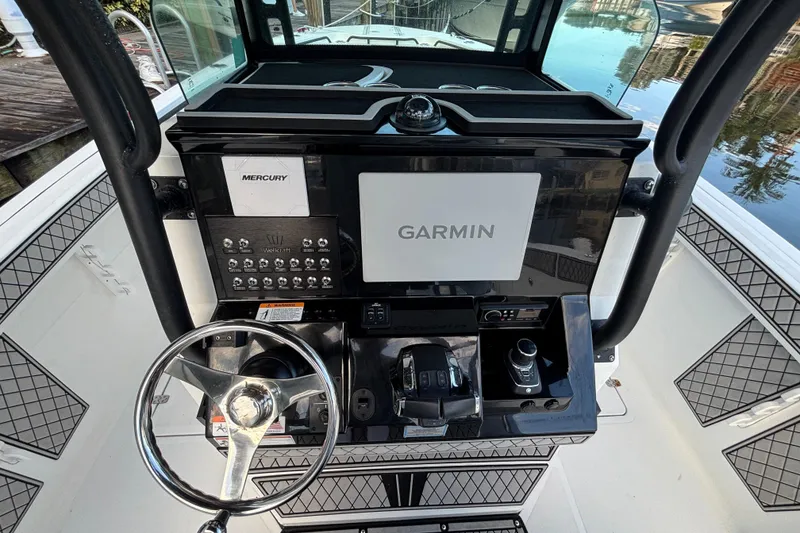 Slide: The Image of 2021 Wellcraft 302 Scarab boat interior with seating, docked by waterfront buildings. - 11