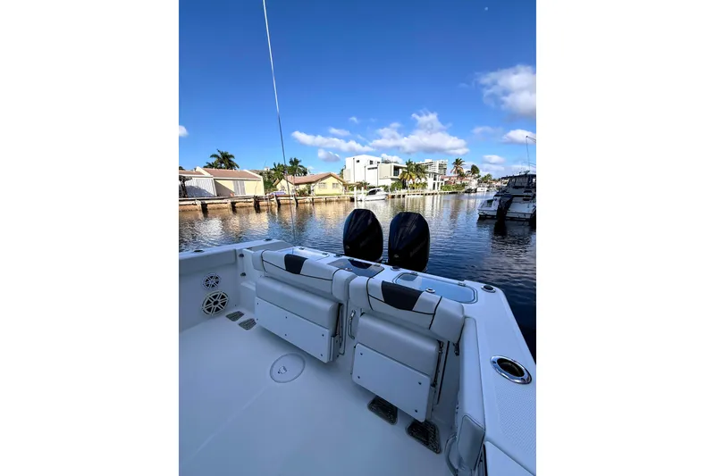 Slide: The Image of 2021 Wellcraft 302 Scarab boat docked, featuring dual engines and a spacious deck. - 19