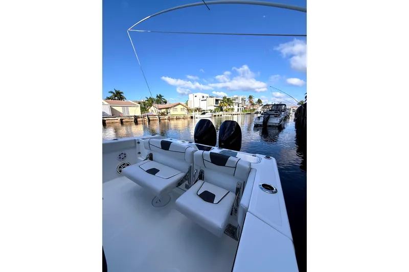 Slide: The Image of 2021 Wellcraft 302 Scarab boat interior with dual engines, docked in a scenic marina. - 22