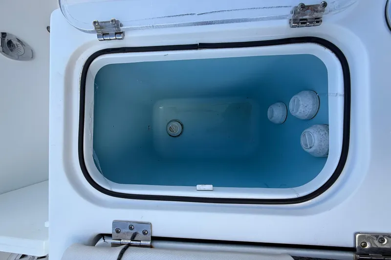 Slide: The Image of Open storage compartment on 2021 Wellcraft 302 Scarab boat, featuring a blue interior. - 26