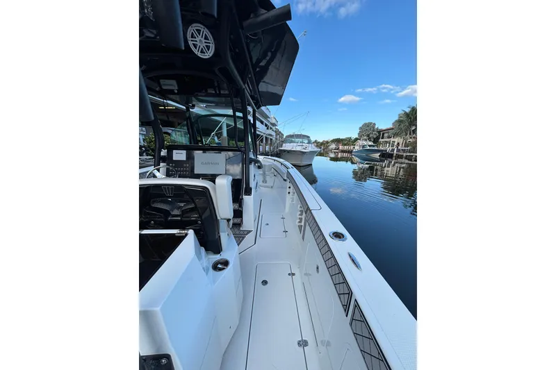 Slide: The Image of 2021 Wellcraft 302 Scarab boat docked, featuring sleek white seating and modern design. - 7