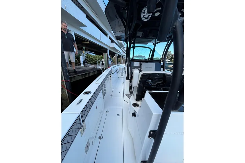 Slide: The Image of 2021 Wellcraft 302 Scarab boat docked, featuring spacious seating and sleek design. - 8