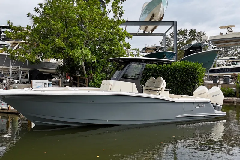 The Image of 2026 Scout 288 LXF boat docked, featuring sleek design and dual Mercury engines. - 0