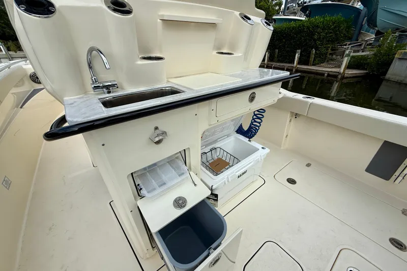 Slide: The Image of 2026 Scout 288 LXF boat with sink, storage, and cooler on deck. - 15