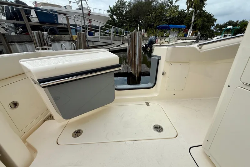 Slide: The Image of 2026 Scout 288 LXF boat interior with open hatch, docked at marina. - 16