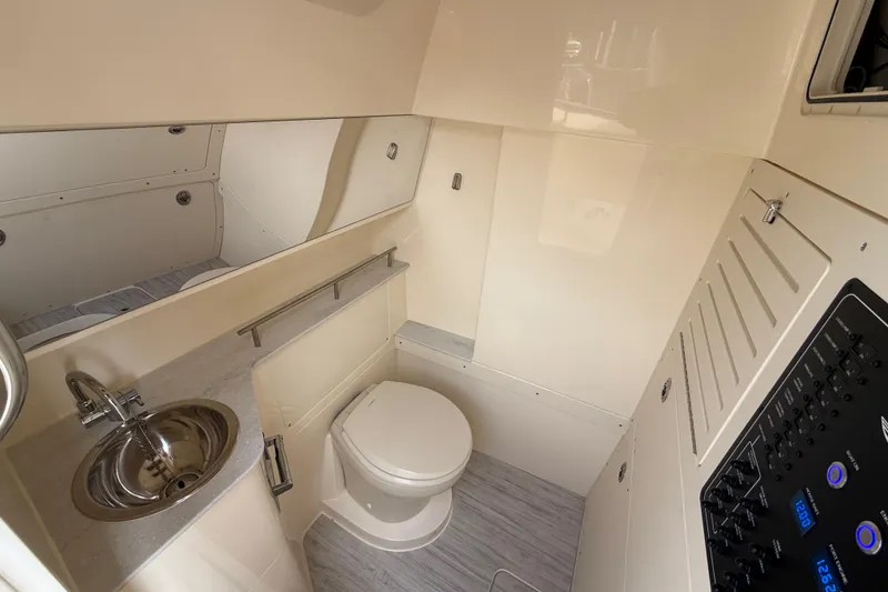 Slide: The Image of 2026 Scout 288 LXF boat interior bathroom with sink, toilet, and control panel. - 19