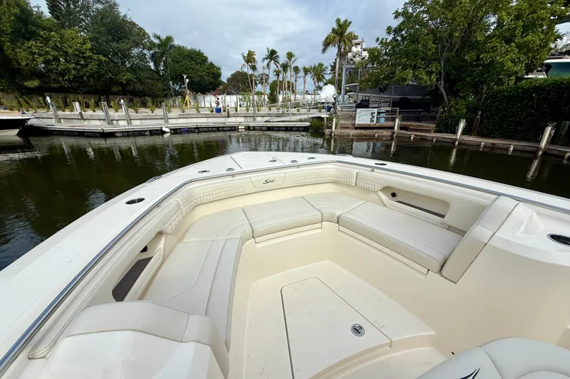 Slide: The Image of 2026 Scout 288 LXF boat with spacious seating at a marina. - 7