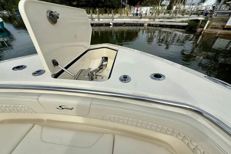 Slide: The Image of 2026 Scout 288 LXF boat with open anchor compartment at dockside. - 8