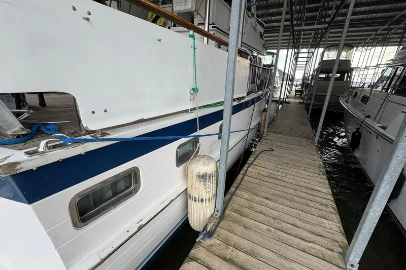 Slide: The Image of 1991 DeFever 44 yacht docked in a covered marina, side view. - 12