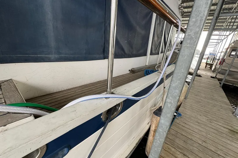 Slide: The Image of 1991 DeFever 44 yacht docked, showing side deck and railing. - 14