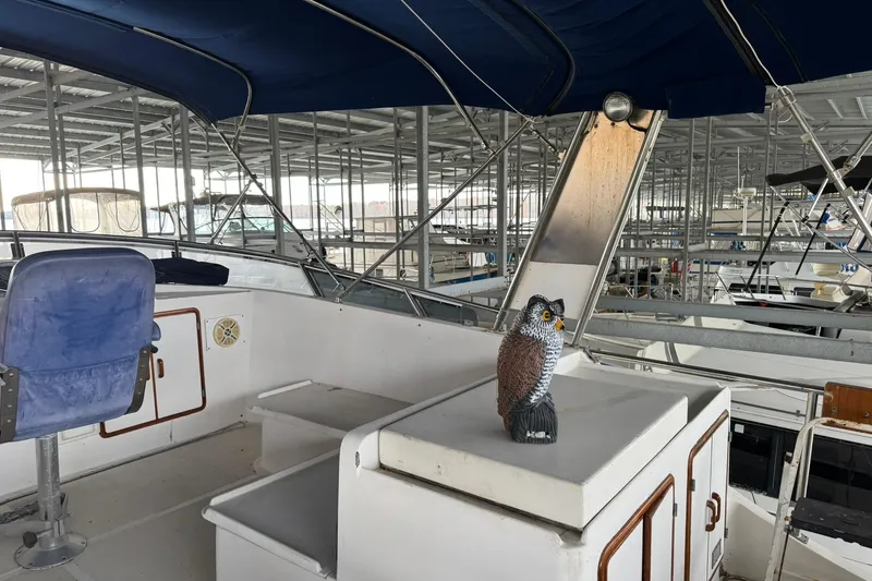 Slide: The Image of 1991 DeFever 44 yacht interior with blue seating and decorative owl statue. - 19