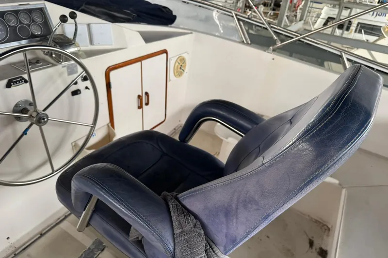 Slide: The Image of Captain's chair and helm of 1991 DeFever 44 yacht, featuring steering wheel and controls. - 22