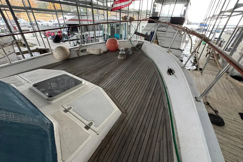 Slide: The Image of 1991 DeFever 44 yacht deck with wooden flooring and docked at marina. - 36