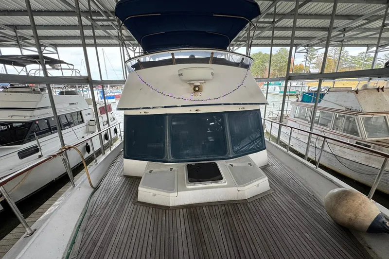Slide: The Image of 1991 DeFever 44 yacht docked in a covered marina, featuring a spacious deck. - 37