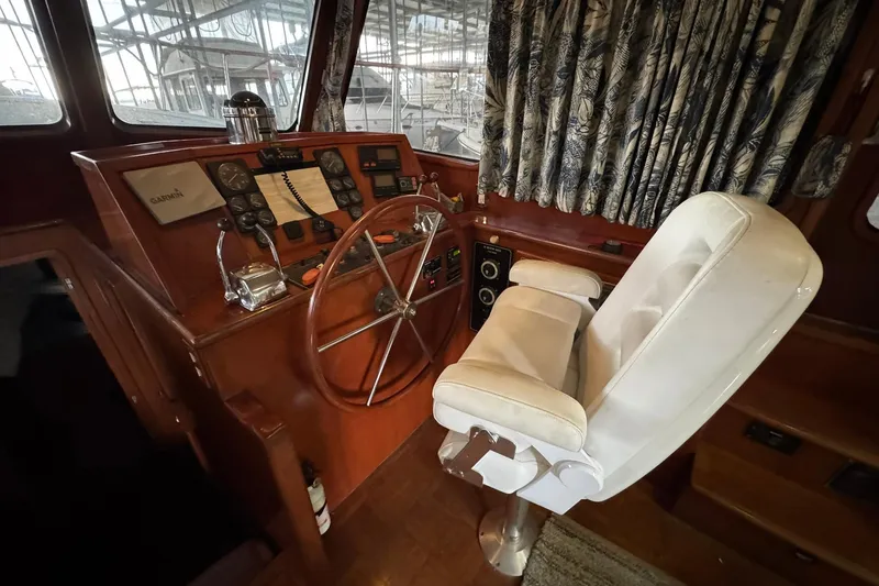 Slide: The Image of 1991 DeFever 44 yacht helm with steering wheel, gauges, and captain's chair. - 44
