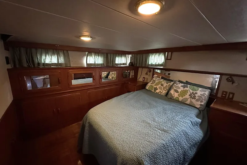 Slide: The Image of Cozy bedroom interior of 1991 DeFever 44 yacht with wood paneling and floral pillows. - 51