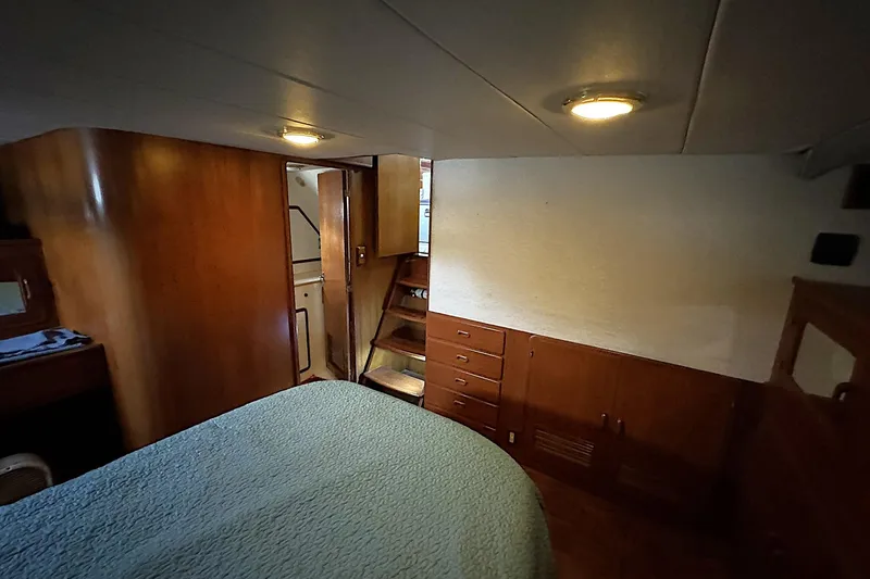Slide: The Image of 1991 DeFever 44 yacht interior cabin with wood paneling and cozy lighting. - 53