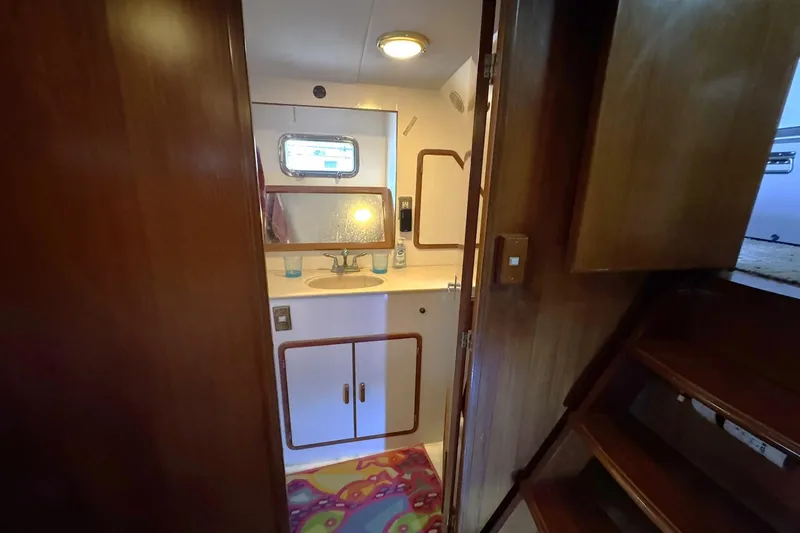 Slide: The Image of Bathroom interior of 1991 DeFever 44 yacht with wooden cabinetry and colorful rug. - 54