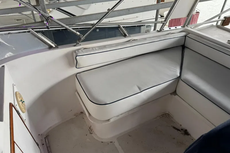 Slide: The Image of 1991 DeFever 44 boat interior with white cushioned seating area. - 68