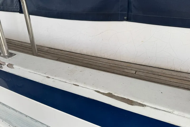 Slide: The Image of Close-up of 1991 DeFever 44 boat railing with visible paint wear. - 8