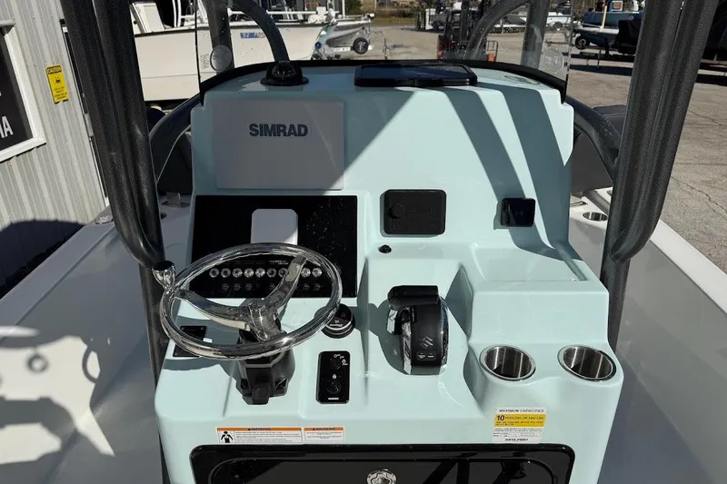 Slide: The Image of 2026 Sea Pro 250 Bay boat console with steering wheel and Simrad electronics. - 12