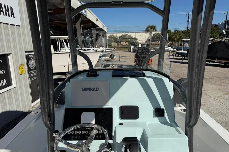 Slide: The Image of 2026 Sea Pro 250 Bay boat dashboard with Simrad display at a dealership. - 13