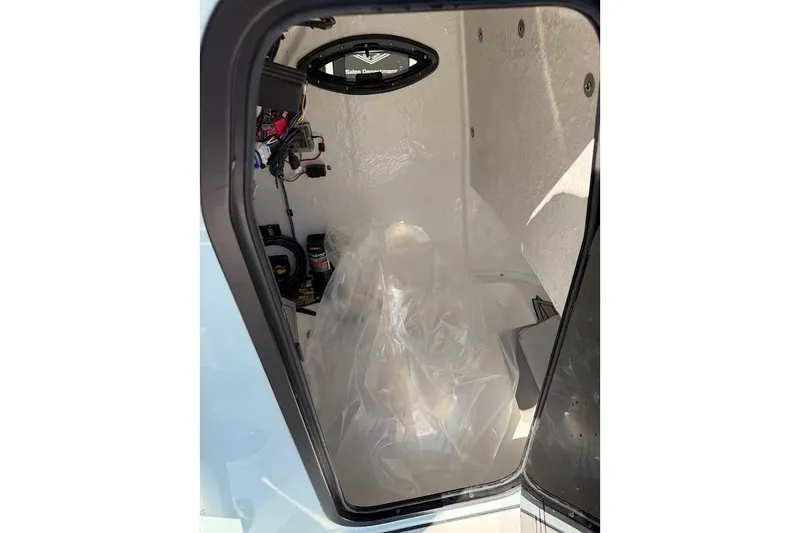 Slide: The Image of Interior view of 2026 Sea Pro 250 Bay boat compartment with wiring and equipment. - 17