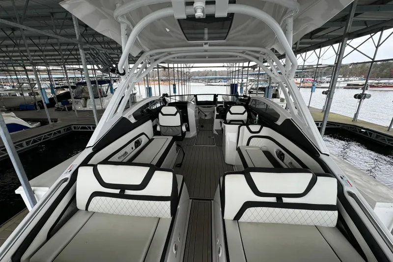 Slide: The Image of 2024 Yamaha Boats 275SD interior with sleek seating and modern design in a marina setting. - 21