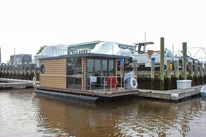 The Image of 2024 Waterlodge Apart M houseboat docked at marina, featuring modern design and glass windows. - 0