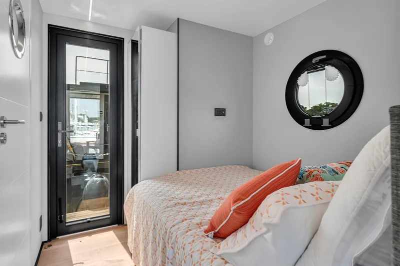 Slide: The Image of Cozy bedroom in 2024 Waterlodge Apart M with modern decor and porthole window. - 15