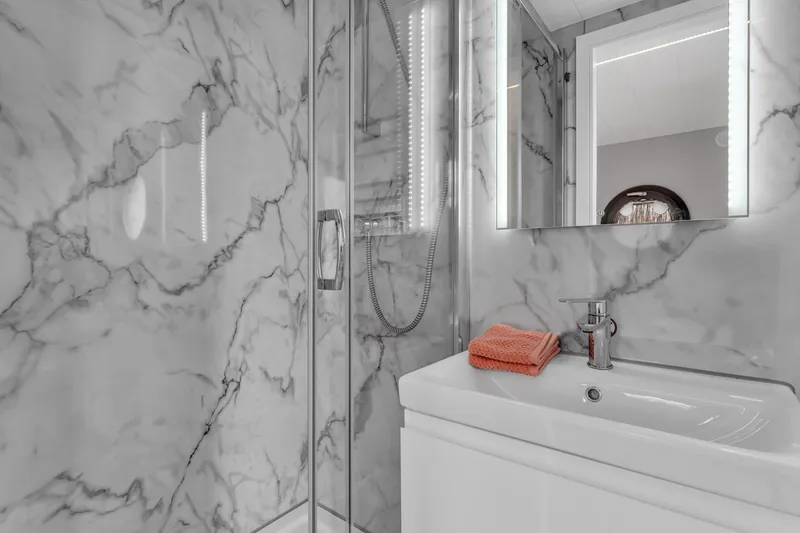 Slide: The Image of Modern bathroom with marble walls, glass shower, and sleek sink in Waterlodge Apart M 2024. - 18