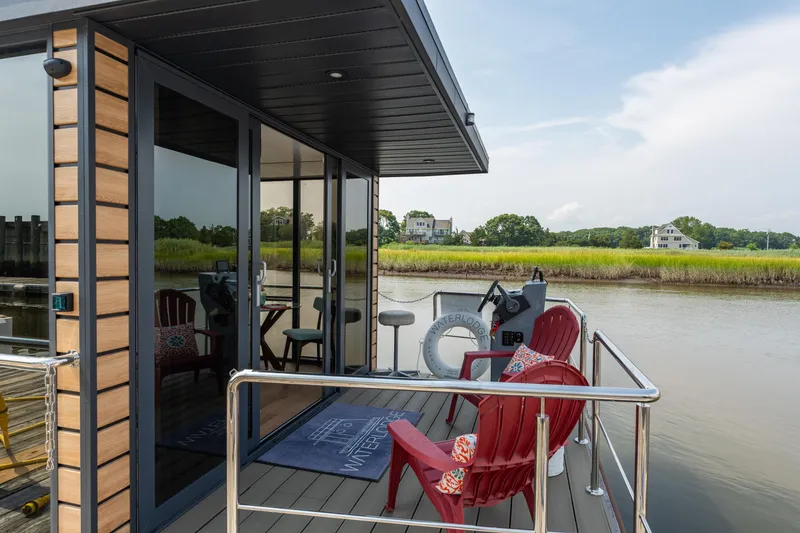 Slide: The Image of 2024 Waterlodge Apart M houseboat with deck chairs, railing, and scenic river view. - 23