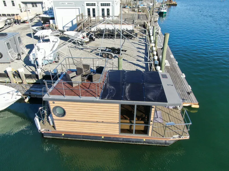 Slide: The Image of 2024 Waterlodge Apart M houseboat docked at marina, featuring solar panels and rooftop seating. - 27