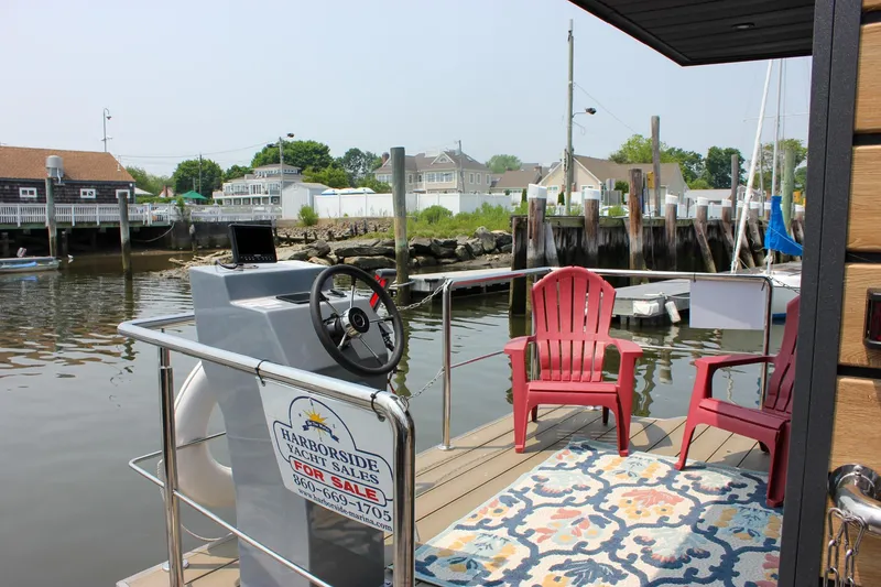 Slide: The Image of Houseboat deck with red chairs, steering wheel, and colorful rug, Waterlodge Apart M 2024 model. - 33