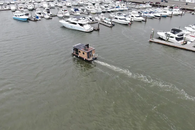 Slide: The Image of Aerial view of 2024 Waterlodge Apart M houseboat navigating near a marina. - 35