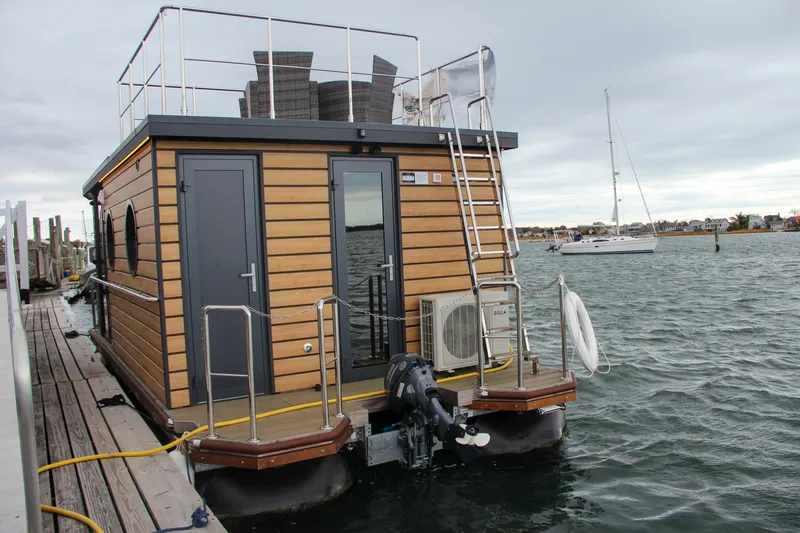 Slide: The Image of Modern 2024 Waterlodge Apart M houseboat docked on a serene waterfront. - 36