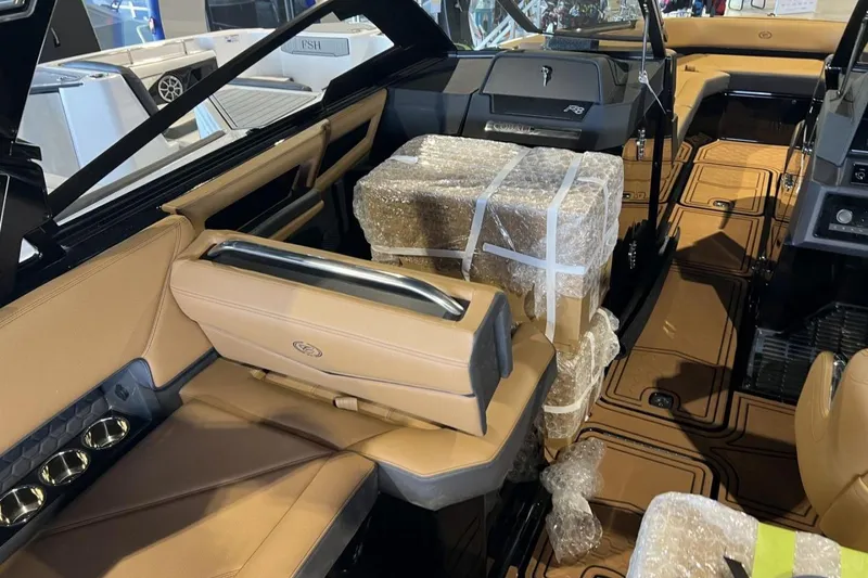 Slide: The Image of 2026 Cobalt R8 Surf boat interior with tan seating and wrapped packages. - 16