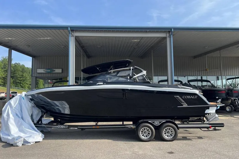 Slide: The Image of 2026 Cobalt R8 Surf boat on trailer at dealership, sleek black design. - 30