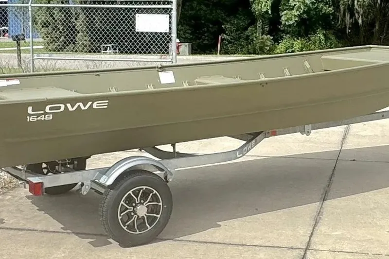 Slide: The Image of 2026 Lowe L1648 Jon boat on trailer, parked outdoors. - 3