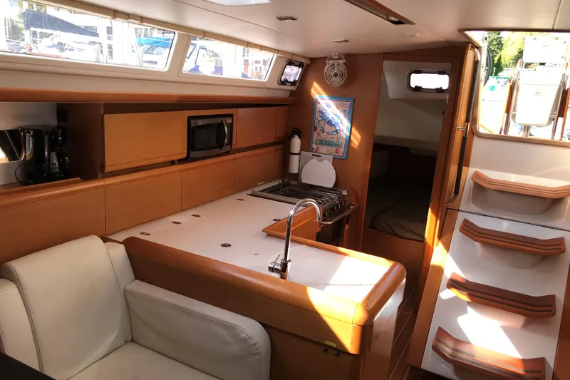 Slide: The Image of Interior of 2015 Jeanneau Sun Odyssey 469 yacht with modern kitchen and seating area. - 11