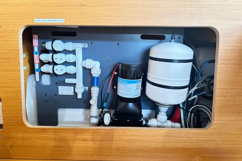 Slide: The Image of Water manifold system in 2015 Jeanneau Sun Odyssey 469 yacht, featuring pipes and pressure tank. - 22