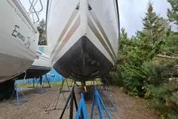 Slide: The Image of 2015 Jeanneau Sun Odyssey 469 sailboat on stands, surrounded by trees. - 39