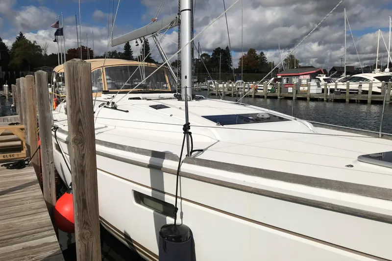 Slide: The Image of 2015 Jeanneau Sun Odyssey 469 sailboat docked at a marina under cloudy skies. - 5