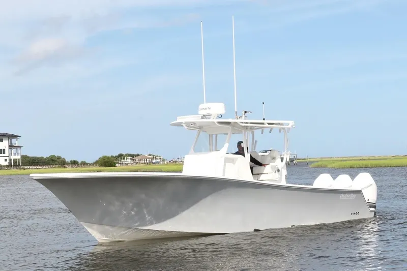 Slide: The Image of 2022 Onslow Bay 33 boat cruising on a calm waterway under a clear blue sky. - 3
